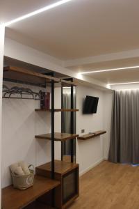 a room with wooden shelves and a television in a room at Vironas Hotel in Himare