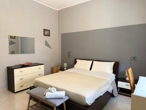 a bedroom with a bed and a chair and a television at RM's Guesthouse in Brindisi
