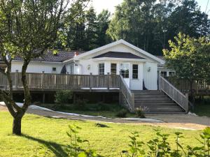 a white house with a porch and a deck at Spacious and well-equipped in Henån