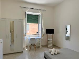 a bedroom with a bed and a desk and a window at RM's Guesthouse in Brindisi