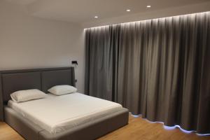 a bedroom with a bed and a window with curtains at Vironas Hotel in Himare