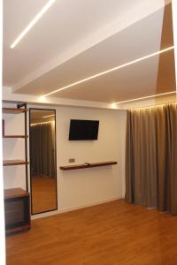a room with a flat screen tv and a mirror at Vironas Hotel in Himare