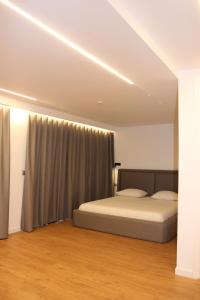 a bedroom with a bed and a curtain at Vironas Hotel in Himare