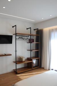 a bedroom with a book shelf and a tv at Vironas Hotel in Himare