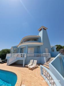 a blue house with a swimming pool in front of it at Villa Quinta da Violeta in Loulé