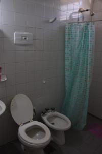 a bathroom with a toilet and a shower curtain at La casa de Mirta Habitaciones en Córdoba in Cordoba