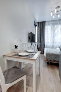 a white room with a table and a bed at The Stay Hub in Kyiv
