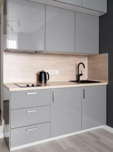 a kitchen with white cabinets and a sink at The Stay Hub in Kyiv