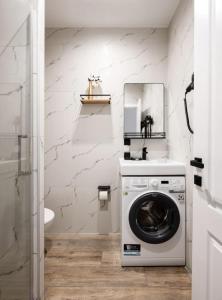 a washing machine in a bathroom with a mirror at The Stay Hub in Kyiv +5 photos