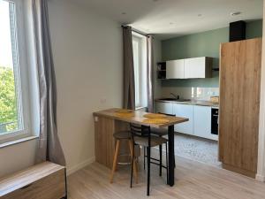 a small kitchen with a wooden table and a counter at Studio indépendant climatisé à Lyon 8 in Lyon