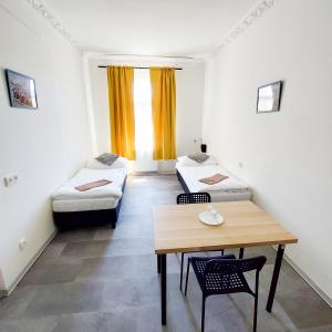 una habitación con dos camas y una mesa y sillas en Pokoj blízko technického muzea G1, en Praga