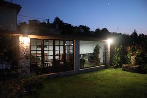 ein Haus mit einem großen Fenster in einem Hof in der Nacht in der Unterkunft Casa de Penim in Paredes de Coura