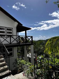 ein Haus mit einer Treppe, die auf einen Balkon führt in der Unterkunft Charming Private Cottage in Gated Estate in Belmont
