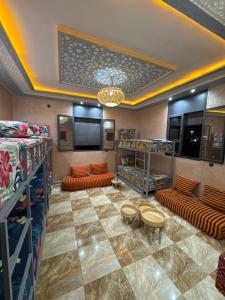 a room with bunk beds and couches and a television at Aéroport hostel et chambre appartement studio Marrakech in Marrakesh