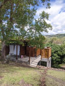 ein Haus mit einer Terrasse und einem Baum in der Unterkunft Charming Private Cottage in Gated Estate in Belmont