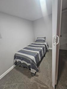 a bed with a striped blanket in a room at Welcome in Woodlawn