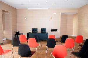 une pièce vide avec un piano et des chaises dans l'établissement AL embaixador, à Alenquer