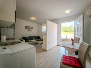 a kitchen and a living room with a table at LUNA APARTMENTS Quiet Retreat, Close to Koper, AirCon, Parking in Ankaran