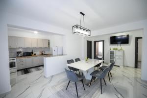 a kitchen and dining room with a white table and chairs at Casa Timiș in Vişeu de Sus