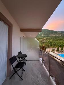 a patio with two chairs and a table on a balcony at NOVO 2025 Apartmani 4S in Kravlja