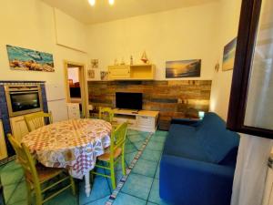 a living room with a table and a blue couch at Villetta Marina in Roseto degli Abruzzi