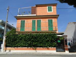 a building with green shutters on the side of it at Villetta Marina in Roseto degli Abruzzi