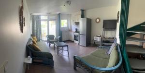 a living room with bunk beds and a kitchen at Spacieux appartement avec terrasse et piscine au Diamant in Le Diamant