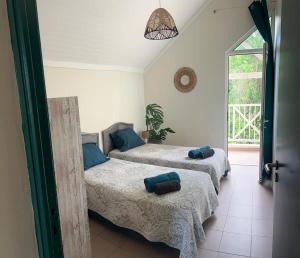 a bedroom with two beds and a window at Spacieux appartement avec terrasse et piscine au Diamant in Le Diamant +18 photos