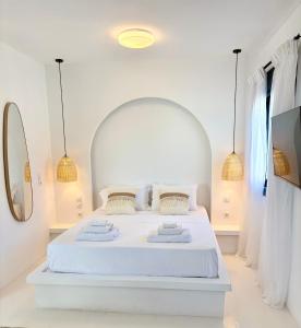 a bedroom with a white bed with two towels on it at Majestic View Villa - Outdoor Jacuzzi in Arkasa