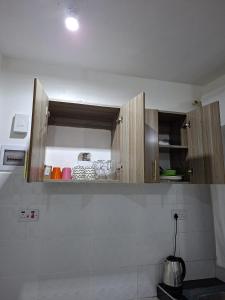モンバサにあるHome by Mercy Apiyoの白いキッチンに木製のキャビネットがあるキッチン +4枚の写真