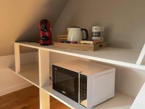 a microwave on a shelf in a room at L'écorce marine in Sangatte