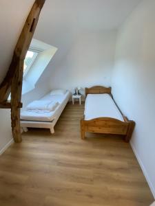 a attic bedroom with two beds and a window at La grange du clos in Angiens