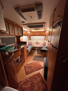 an rv with a kitchen and a table in it at TOP LAGE 2 Personen Volkach Wohnwagen Luxus in Volkach
