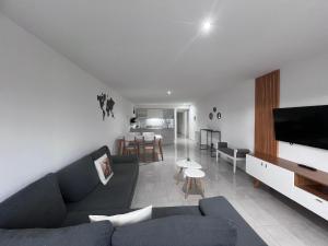 un salon avec un canapé bleu et une cuisine dans l'établissement Departamento centrico Bariloche - Rolando, à San Carlos de Bariloche 4 autres photos