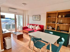 a living room with a red couch and a table at Frutillar borde lago in Frutillar