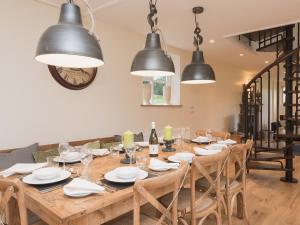 een eetkamer met een houten tafel en black lights bij Hall Cottage in Brampton