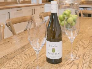 een fles wijn op tafel met twee glazen bij Hall Cottage in Brampton