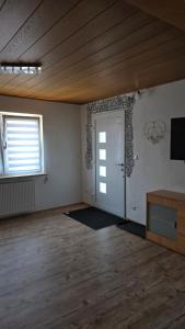 an empty room with a door and a television in it at Hüller Ferienwohnung in Gräfenberg