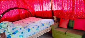 a bedroom with a bed with a red curtain at La Chonta de Corcovado in Puerto Jiménez