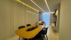 una sala da pranzo con tavolo e sedie in legno di Praia Luxo e Conforto a Vila Velha Altre 52 foto