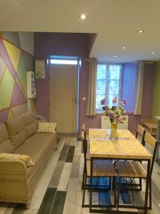 a living room with a couch and a table at fleurs de printemps - Jonquille chic in Vrécourt