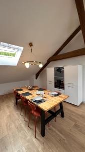 a dining room with a wooden table and chairs at Le ONZE in Longwy +40 photos