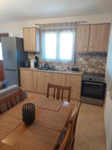 a kitchen with a wooden table and a kitchen with a refrigerator at Μοντέρνο Σπίτι in Monemvasia +16 photos