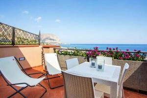 a table and chairs on a balcony with the ocean at Mondello Addaura Home Holiday in Mondello
