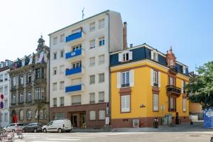 a yellow and white building on a city street at Love Room Strasbourg - Jacuzzi & Sauna - Yellow in Strasbourg