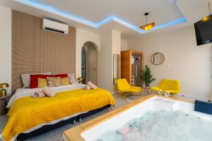 a bedroom with a bed and a tub at Love Room Strasbourg - Jacuzzi & Sauna - Yellow in Strasbourg
