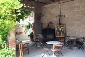een patio met tafels en stoelen en een bakstenen muur bij Ca la Flora in Banyoles