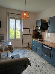 a kitchen with a couch and a table in a room at Doux Ombrages in La Bourboule
