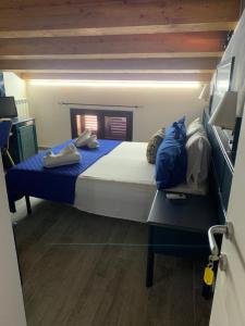 a bedroom with a large bed with blue sheets at U muragliuni 1 in Lascari +8 photos