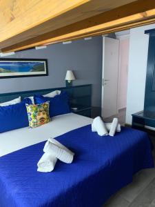 a bedroom with a large bed with blue sheets at U muragliuni 1 in Lascari
